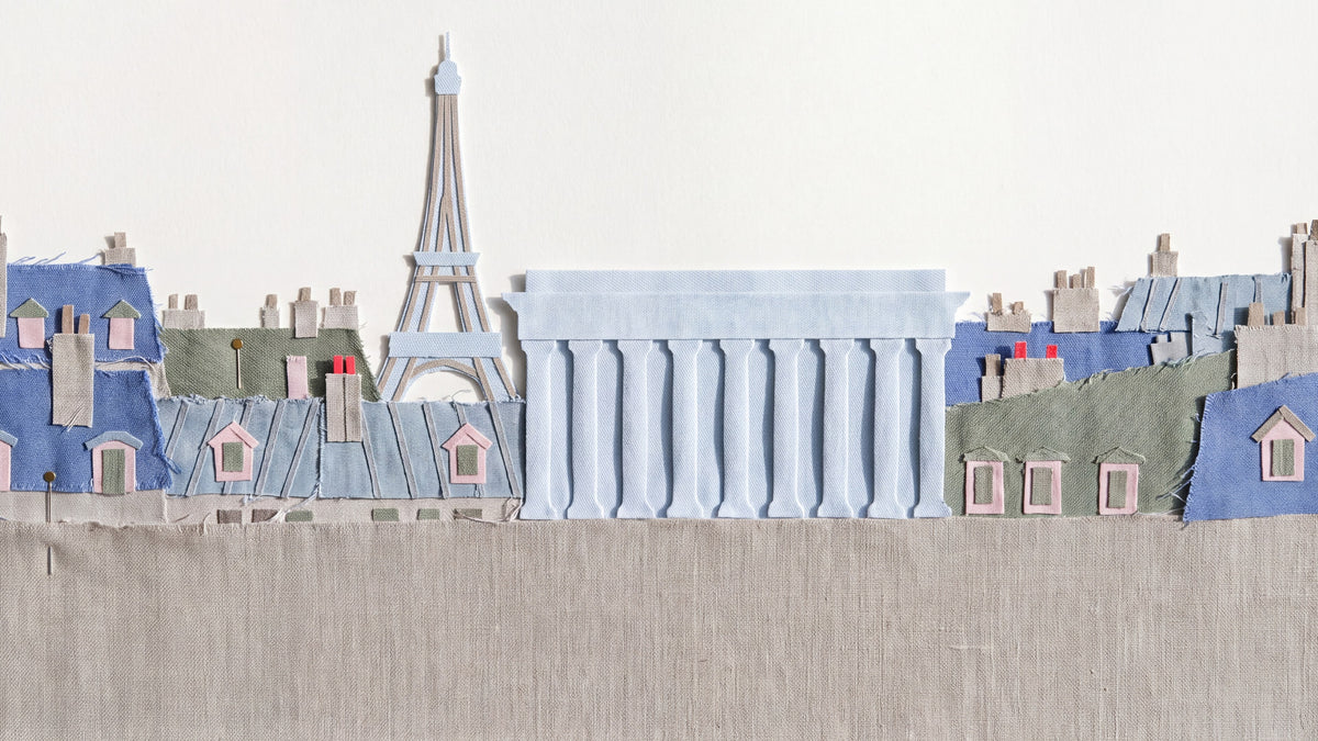 Cloth-collage illustration of the Paris roofline with the Eiffel Tower beside the colonnade of the Palais Brongniart, in the garment-dyed colours of the Ploumanac'h SS27 collection